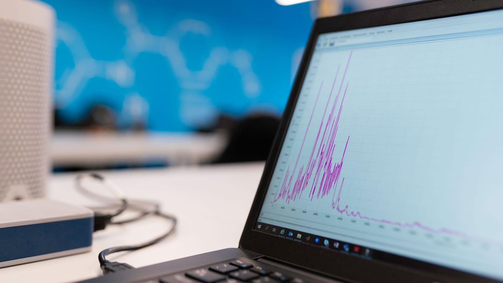 A laptop on a desk showing a traffic graph