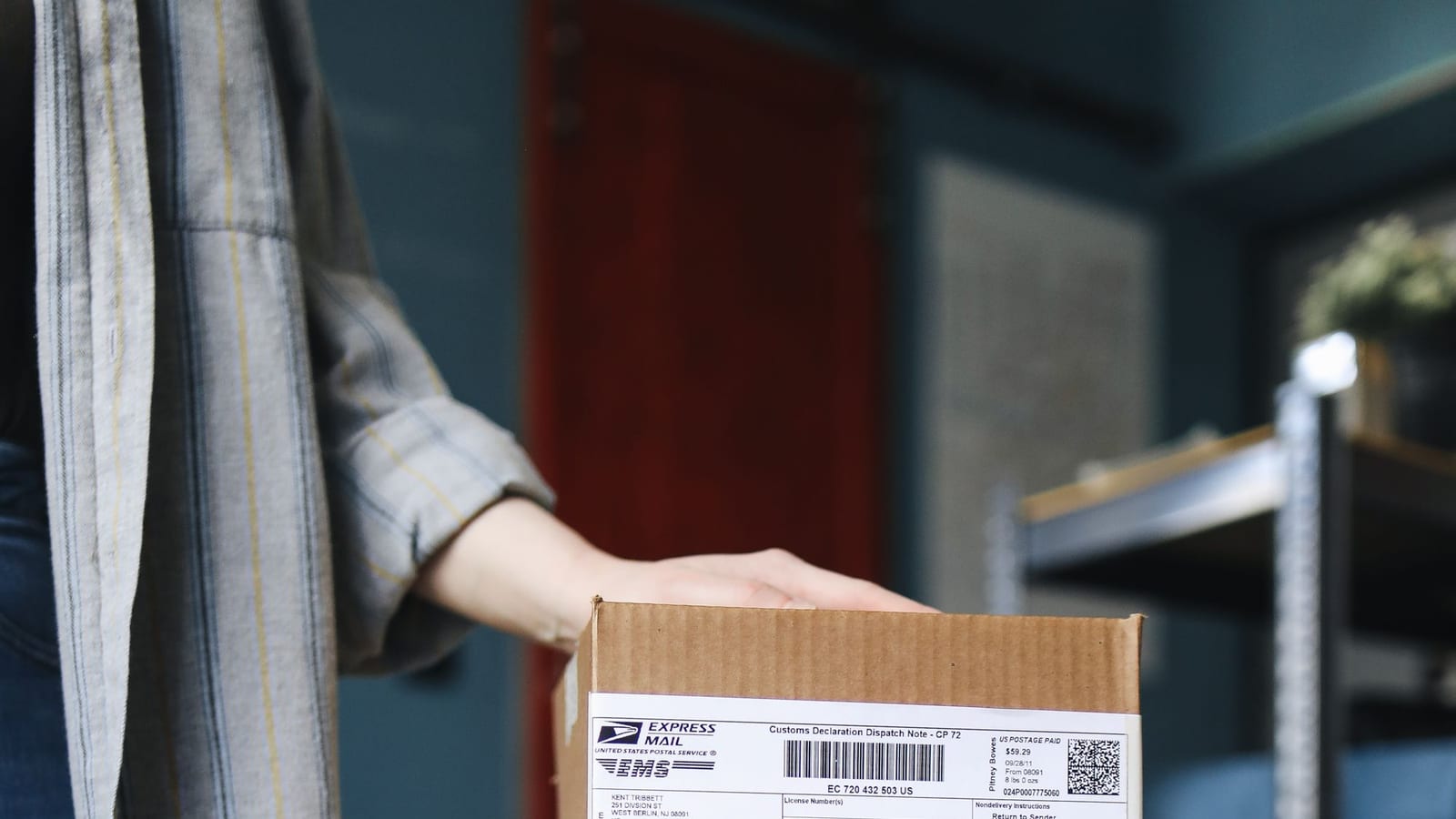 A person stacking cardboard parcels with shipping labels