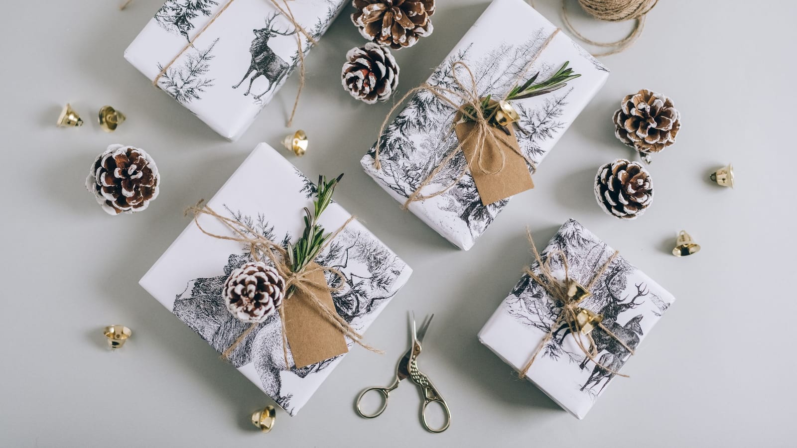 Gifts wrapped in patterned paper with twine and pine cones