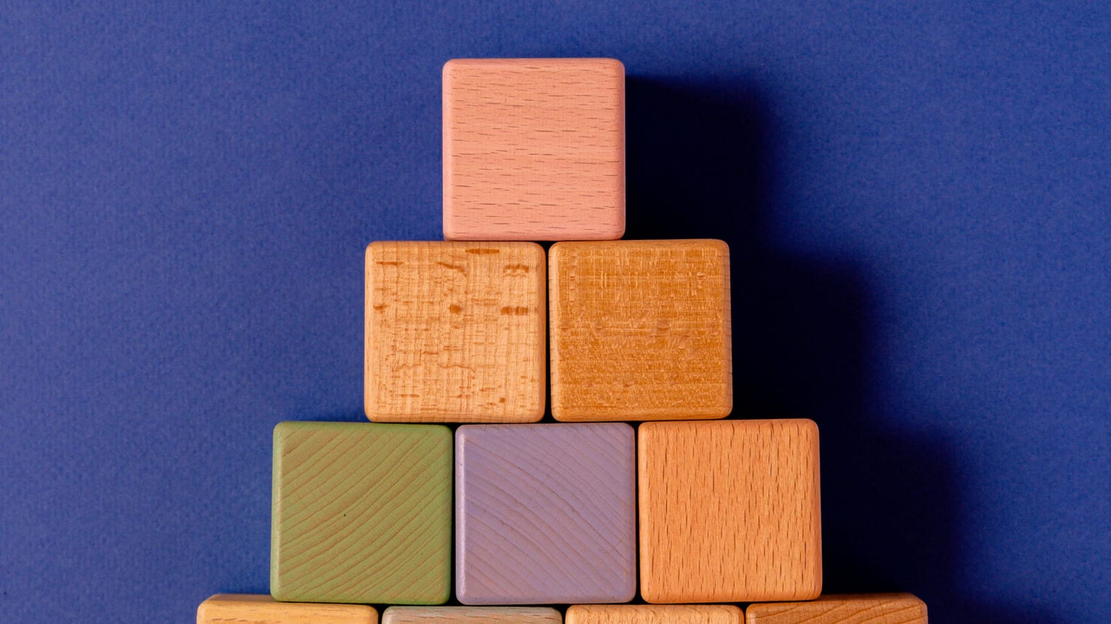 Wooden blocks stacked into a pyramid on a blue background