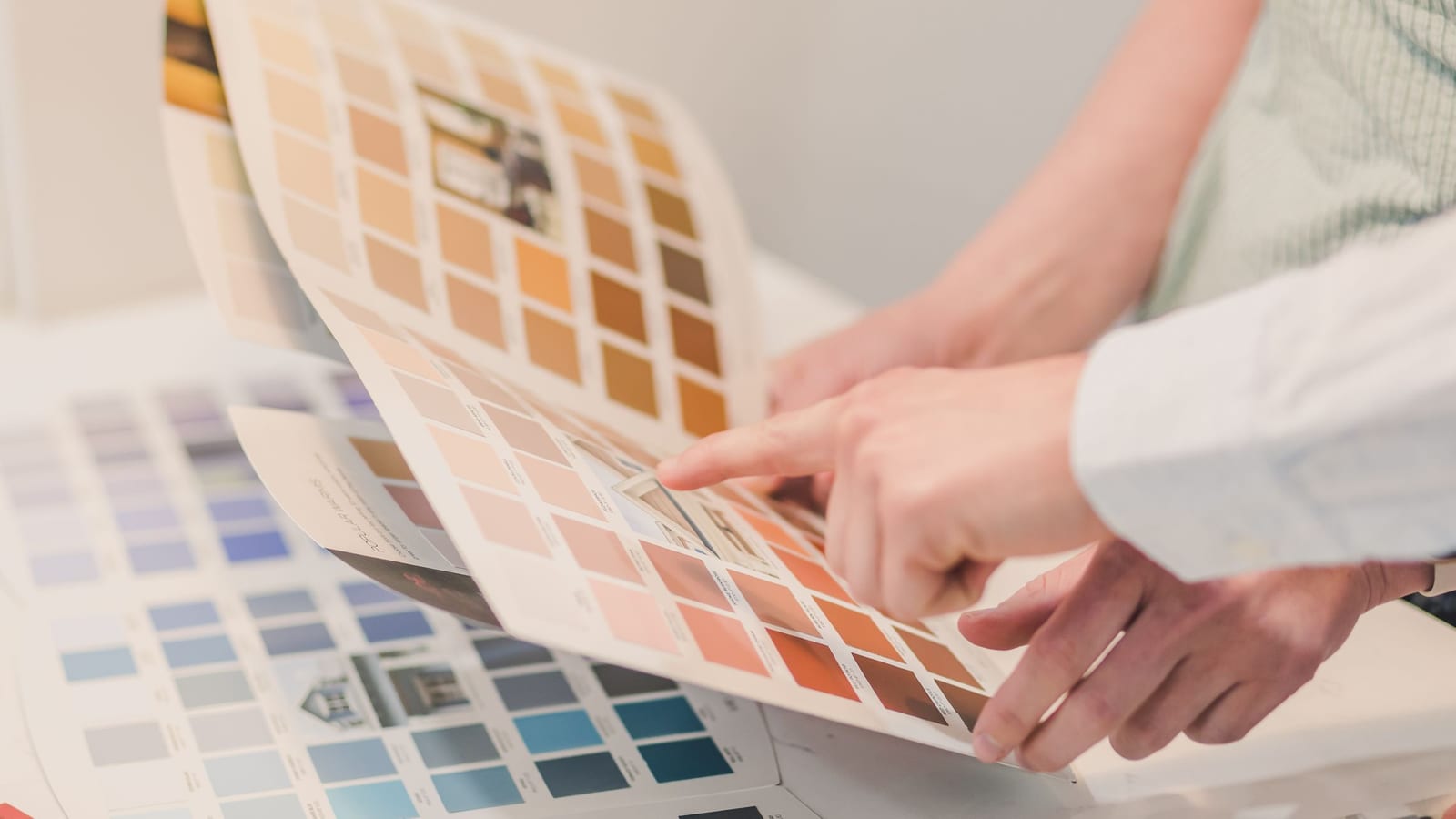 Two people comparing colour swatches in a brochure